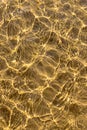 Sunlit water forming wavy textures over sandy bottom Royalty Free Stock Photo