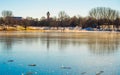 Sunlit winter landscape at frozen lake, blue sky and trees reflected on ice Royalty Free Stock Photo