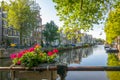 Sunny Amsterdam Canal and Flowers on the Fence Royalty Free Stock Photo