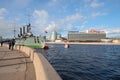 A sunny April day on the Petrogradskaya embankment. View of the cruiser `Aurora` and the `St. Petersburg` hotel