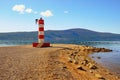 Sunny autumn day, beautiful Mediterranean landscape.  Montenegro. Coast of Bay of Kotor. Deserted pebble beach with beacon Royalty Free Stock Photo