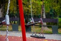On a sunny autumn day, the children`s swing is empty on the playground Royalty Free Stock Photo