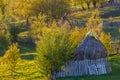 Sunny autumn mountain landscape with stacks. Beautiful sunny autumn mountain view with hay stacks, rustic fence and sunny yellow Royalty Free Stock Photo