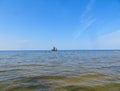 Sunny beach and blue water and a pleasure boat on the shore of the Gulf of Riga. 29, July, 2018, Latvia, Jurmala