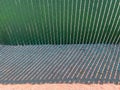 sunny beach fencing green mesh slat chainlink fence steel industrial yard security privacy shadows Royalty Free Stock Photo