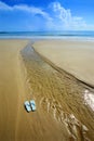 Sunny beach, flip flops on sand Royalty Free Stock Photo