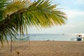 Sunny beach landscape with volleyball net and palm leaf. Tropical island day view. Relaxing sunny seascape Royalty Free Stock Photo