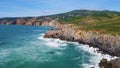 Sunny beautiful seascape ocean waves splashing on rocky coast. Aerial foamy sea Royalty Free Stock Photo