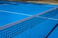 Sunny blue tennis court with net. Empty sport field photo. Hard court cover for lawn tennis. Summer sport activity Royalty Free Stock Photo