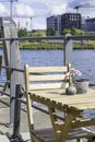 Sunny cozy seat at a wooden cafe table on the shore of Baakenhafen in Hamburg. View of the new Baakenpark in the Royalty Free Stock Photo