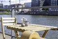 Sunny cozy seat at a wooden cafe table on the shore of Baakenhafen in Hamburg. View of the new Baakenpark in the Royalty Free Stock Photo