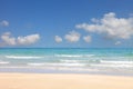 Sunny day at the beach with bright blue sky and fluffy white cloud on the sea horizon with copy space