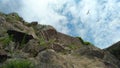 Perspective view of a rock under a blue sky with birds flying freely