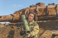 Girl in uniform with a Bazooka on the background of a broken tan