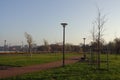 Sunny day with green grass and blue sky. Young trees. Reidi tee promenade. Modern space for walking and rest in a city