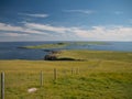 On a sunny day with light clouds, the island of Balta from the Keen of Hamar near Baltasound on the island of Unst in Shetland