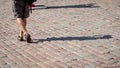 On a sunny day, a man walk along the sidewalk. The human shadows Royalty Free Stock Photo