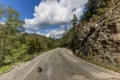 Sunny day on a mountain road, blue sky with clouds and a french bulldog on an empty road Royalty Free Stock Photo