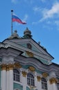 Sunny day in Saint-Petersburg, russian flag flying above facade of Hermitage State Museum Royalty Free Stock Photo