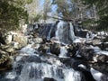 Sunny day during spring when snow melts water rushes down this nice waterfall