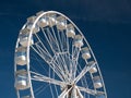 On a sunny day in summer against a deep blue sky, the white steelwork and gondolas of the big wheel tourist attraction at Portrush Royalty Free Stock Photo