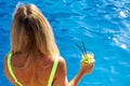 On sunny day, tanned girl relaxes by water, drinks cool mahito with ice Royalty Free Stock Photo