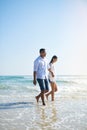 Sunny days bring so much calm and joy. a young couple taking a stroll along the beach. Royalty Free Stock Photo