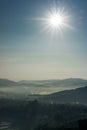 Sunny and foggy morning at village under the hill Royalty Free Stock Photo