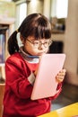 Beautiful little sunny girl feeling joyful while drawing pictures