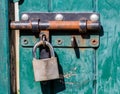 Sunny green blue wooden door with rusted lock for colors Royalty Free Stock Photo