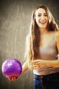 Young woman with long brown hair playing with purple ball. Royalty Free Stock Photo