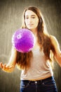 Young woman with long brown hair playing with purple ball. Royalty Free Stock Photo