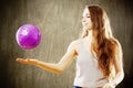 Young woman with long brown hair playing with purple ball. Royalty Free Stock Photo