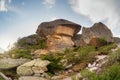 Sunny highland scenery with big stones of unusual shape. Awesome scenic mountain landscape with big cracked stones closeup among