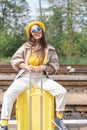 Sunny holidays: a female look in bright clothes and sunglasses promises a warm and exciting journey. Dream suitcase: a