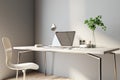 Sunny home office work place with light wooden furniture, modern laptop and coffee mug