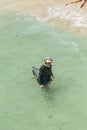 man searches with metal detector for tresuries in the ocean