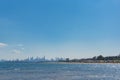 Sunny landscape with city skyline and beach with colorful beach