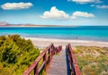 Sunny maribe scenery. Wooden footbridge to the oasis-like beach - Spiaggia della Pelosa Royalty Free Stock Photo