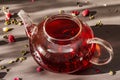 Sunny morning breakfast. Sweet raspberry green tea in glass kettle with dry fruits, flowers and leaves Royalty Free Stock Photo