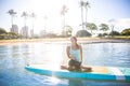 Sunny morning sun flare moment of a pretty young woman in SUP Yo Royalty Free Stock Photo