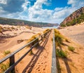 Sunny morning view of Cala Domestica beach. Bright summer scene of Sardinia, Italy, Europe. Footbridge in Canyon di Cala Domestica Royalty Free Stock Photo