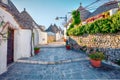 Sunny morning view of strret with trullo trulli - traditional Apulian dry stone hut with a conical roof. Bright spring cityscap