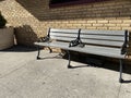 Sunny outdoor brick wall  and wood metal bench on walkway Royalty Free Stock Photo