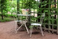 Sunny outdoor cafe with wrought iron white furniture Royalty Free Stock Photo