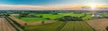 Sunny panorama of rural idyll with agricultural factory, industrial plant of natural fiber industry, fields on the background in