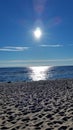 Sunny path reflection on the sea water, near sandy beach