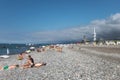 Batumi. Georgia - September 2, 2014. Black sea pebble beach with sunbathing people, Alphabeth tower and Technological