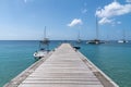 Sunny piers on the ocean with sailing boat - Martinique island, Anses Arlet village