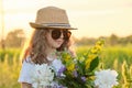 Sunny portrait of girl child in hat sunglasses with flowers in meadow Royalty Free Stock Photo